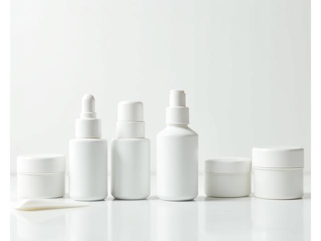 Witte ongemerkte cosmeticaflessen op een plank, symbool voor private-label services.